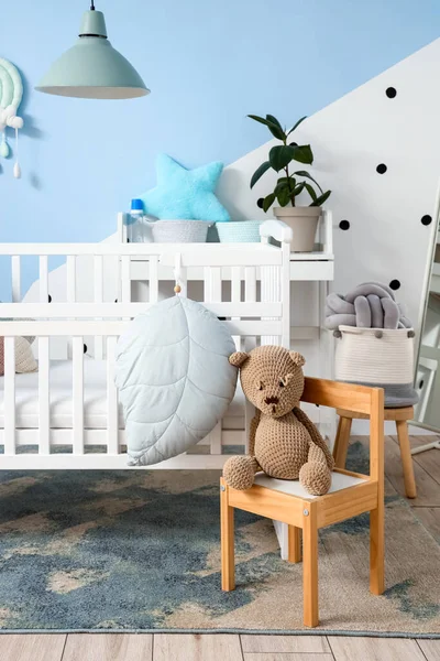Baby crib and chair with toy in children\'s bedroom