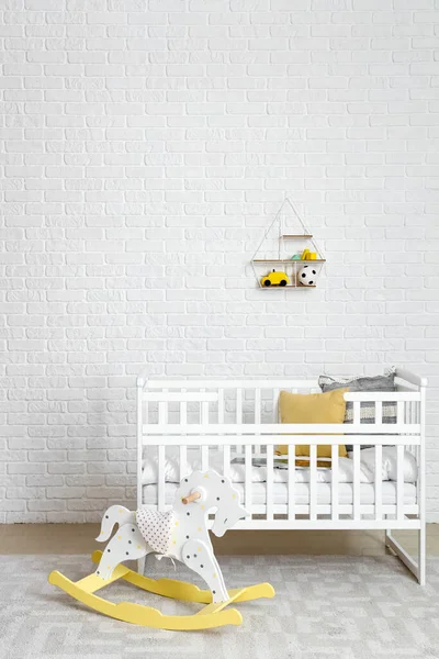 Interior of children's bedroom with crib and rocking horse