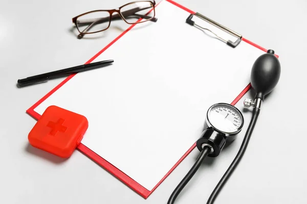 白色背景的带眼镜和血压计的空白剪贴板 世界卫生日 — 图库照片