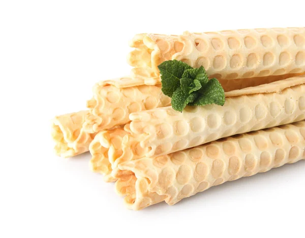 Stack of delicious wafer rolls with mint isolated on white background