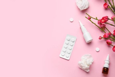 Nasal drops with pills, flowers and tissues on pink background. Seasonal allergy concept