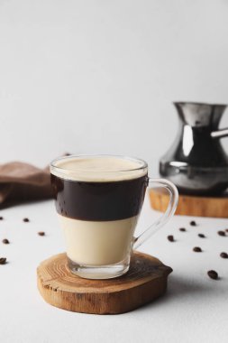 Glass cup of delicious Cafe Bombon on light table