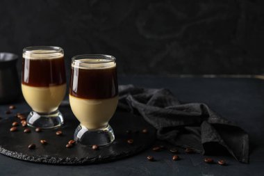 Glasses of tasty Cafe Bombon on dark background