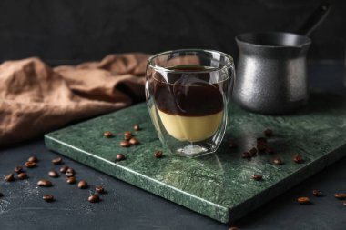 Koyu arkaplanda bir bardak lezzetli Cafe Bombon.