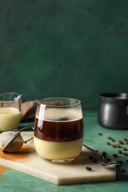 Board with glass of tasty Cafe Bombon on color background