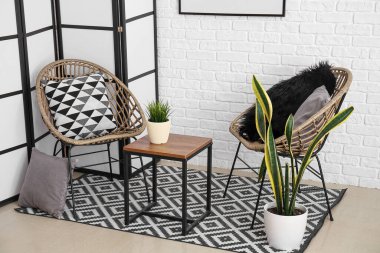 Interior of cozy living room with folding screen, chairs and table