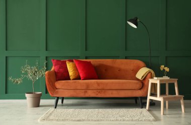 Interior of stylish living room with red sofa, stepladder and lamp