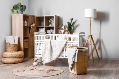 Interior of children's bedroom with baby crib and shelving unit