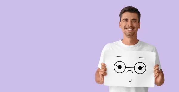 Handsome Young Man Holding Paper Cute Emoticon Lilac Background Space — Φωτογραφία Αρχείου