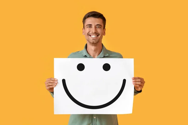 Smiling Young Man Holding Paper Happy Emoticon Yellow Background — ストック写真