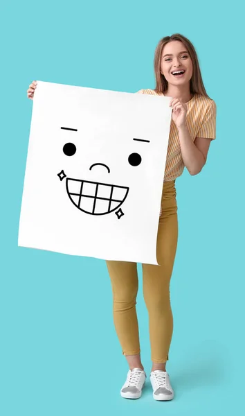 Happy Young Woman Holding Paper Smiling Emoticon Light Blue Background — Foto de Stock