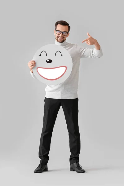 Happy Man Holding Papier Met Glimlachende Emoticon Lichte Achtergrond — Stockfoto