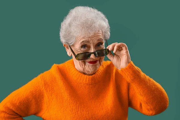 Senior Woman Sunglasses Orange Sweater Green Background Closeup — Stockfoto