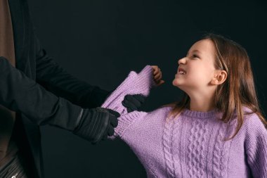 Karanlık arka planda terörist ve korkmuş küçük rehine.