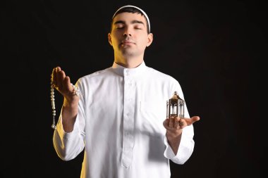 Praying Muslim man on dark background