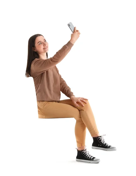 스마트폰을 예쁘고 의자에 앉아서 배경에 셀카를 있습니다 — 스톡 사진