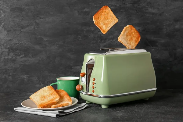 现代烤面包机 黑桌上有脆面包片和杯子 — 图库照片