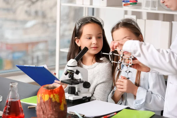 分子モデルを用いた化学の先生は理科の教室で女の子にレッスンを行う — ストック写真