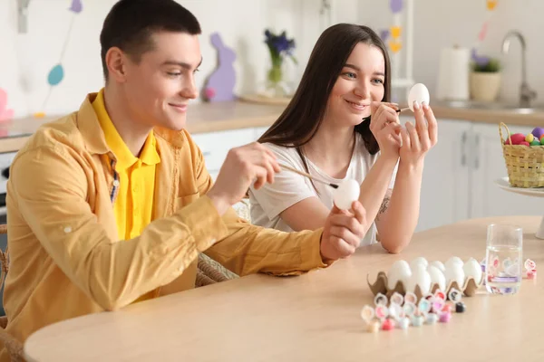 Young Woman Painting Easter Eggs Her Boyfriend Kitchen — Stock Photo, Image