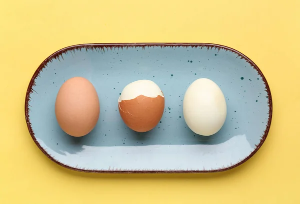 Plaat Met Geschilde Ongepelde Gekookte Eieren Gele Achtergrond — Stockfoto