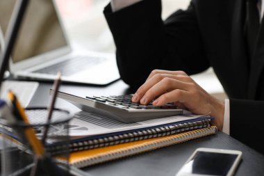 Ofiste hesap makinesiyle çalışan erkek muhasebeci, yakın plan.