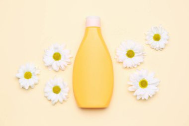Renkli arka planda bir şişe kozmetik ürünü ve papatya çiçeği.