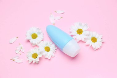 Kozmetik ürünleri ve pembe arka planda taze papatya çiçekleri olan kompozisyon