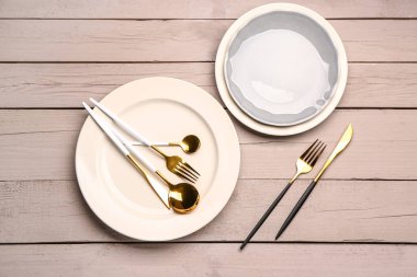 Tabaklar ve çatal bıçak seti beyaz ahşap arka planda