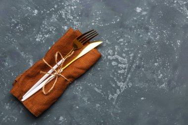 Gri arka planda çatal ve bıçaklı peçete.
