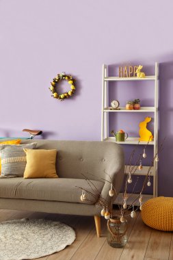 Interior of living room with Easter wreath and grey sofa