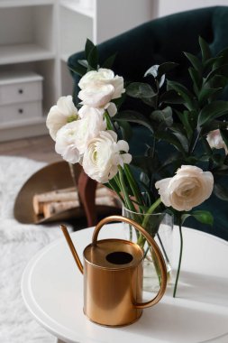 Oturma odasındaki masada ranunculus çiçekli vazo, yakın plan.