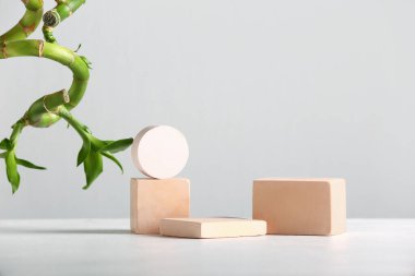 Green bamboo stems and plaster podiums on white background