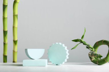 Green bamboo stems and plaster podiums on white background