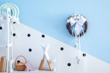 Çocuk odasındaki renkli duvarda asılı Paskalya çelengi