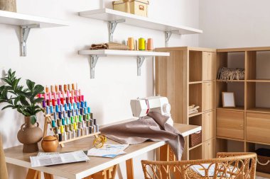 Atölyede iplik makaralı ve dikiş makineli terzi işyeri