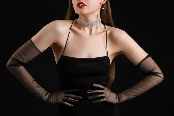 stock image Beautiful woman in black dress with love bites on her neck against dark background