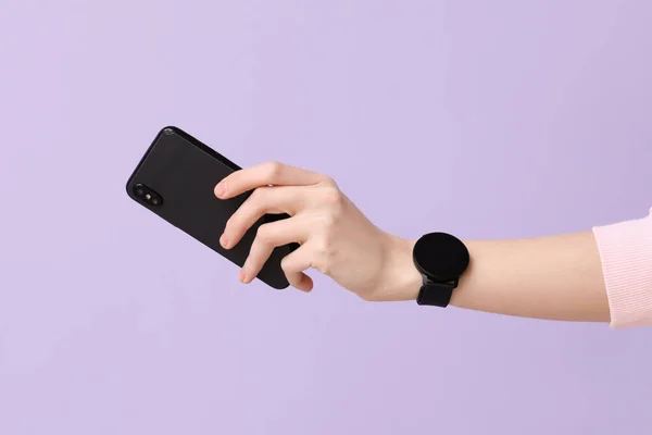 Vrouw Met Smartwatch Mobiele Telefoon Lila Achtergrond — Stockfoto