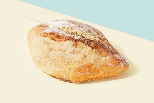 Mavi Duvarın Yanındaki Bej Masada Bir Somun Taze Ekmek Buğday — Stok fotoğraf