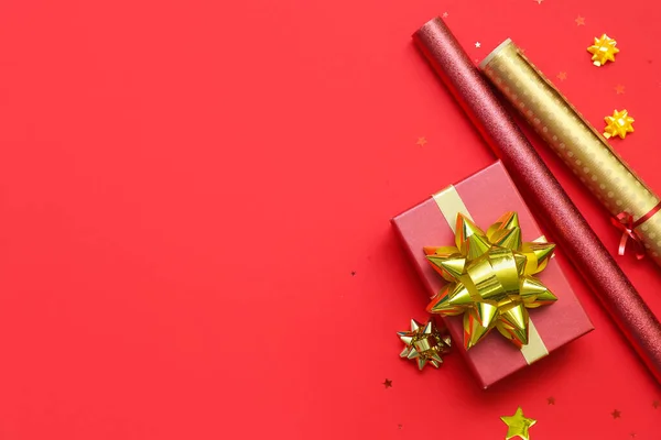 Geschenkkarton Mit Goldenen Schleifen Und Geschenkpapier Auf Rotem Hintergrund — Stockfoto