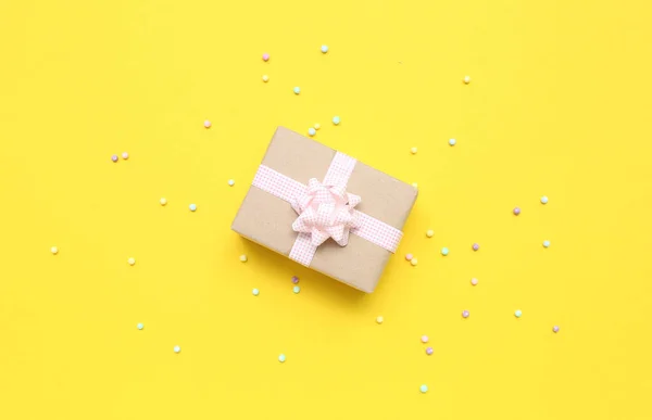 Geschenkkarton Mit Rosa Karierter Schleife Und Perlen Auf Gelbem Hintergrund — Stockfoto