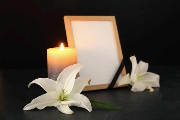 暗いテーブルの上に空白の葬儀フレーム 燃えるろうそくとユリの花 — ストック写真