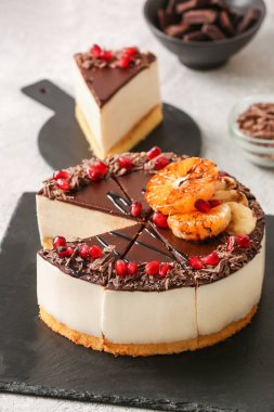 Slate board with tasty birds milk cake on light background, closeup