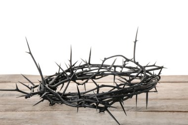 Crown of thorns on wooden table against white background