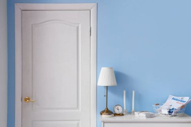 Salonda lamba, saat ve mumlarla dolu çekmeceler.