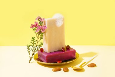 Composition with soap bars and natural ingredients on color background