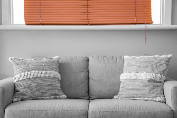 Szara Sofa Poduszkami Pobliżu Białej Ściany — Zdjęcie stockowe