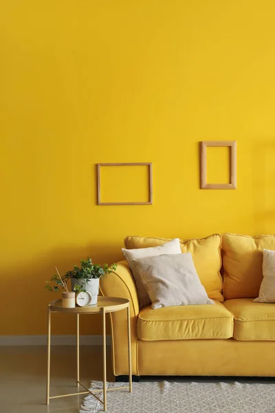 Interior of living room with yellow sofa and table