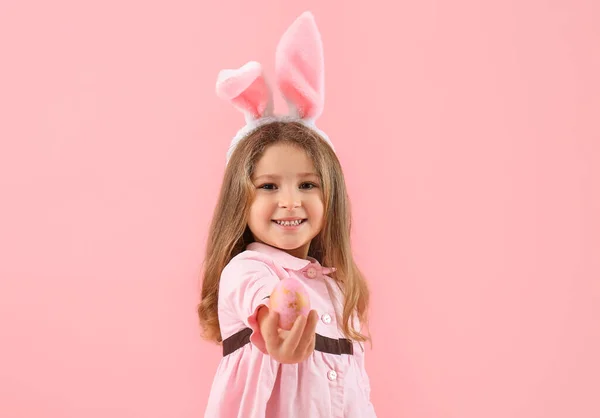 可爱的小女孩 戴着粉色背景的复活节彩蛋 长着小兔子耳朵 — 图库照片