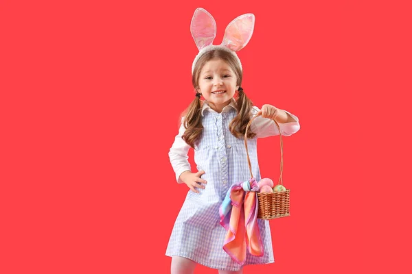 Roztomilé Holčička Zajíček Uši Košíkem Velikonočních Vajec Červeném Pozadí — Stock fotografie