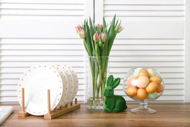 Paskalya yumurtaları, tavşancık ve vazo, mutfak tezgahında lale çiçekleri.